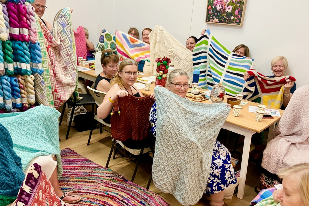 Knitters and crocheters showcasing their finished handmade projects at That Yarn Place workshop.