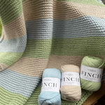 Fiddlesticks Finch 10 ply Cotton Yarn. Striped knit blanket in green, blue and beige yarn.