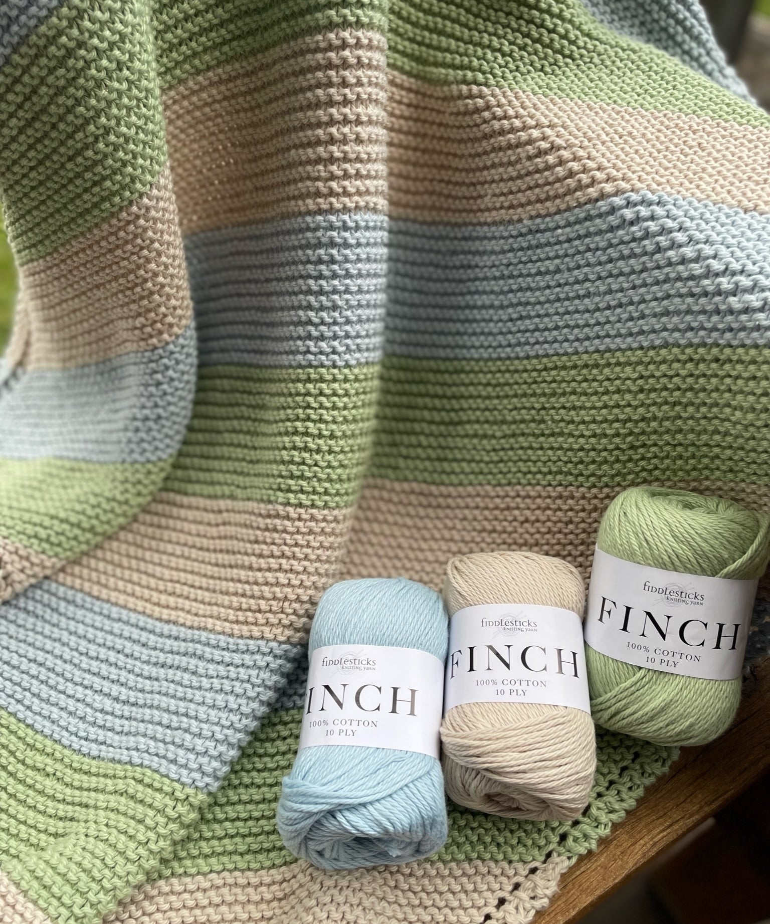 Fiddlesticks Finch 10 ply Cotton Yarn. Striped knit blanket in green, blue and beige yarn.
