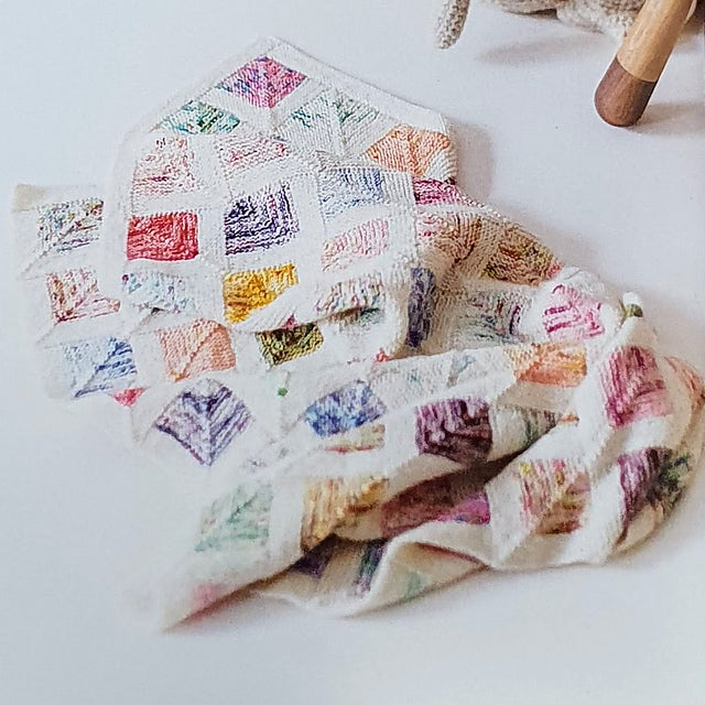 Domino Baby Blanket knitting project by Sylvia Roozeboom, showing geometric blocks with contrasting solid and speckled yarn